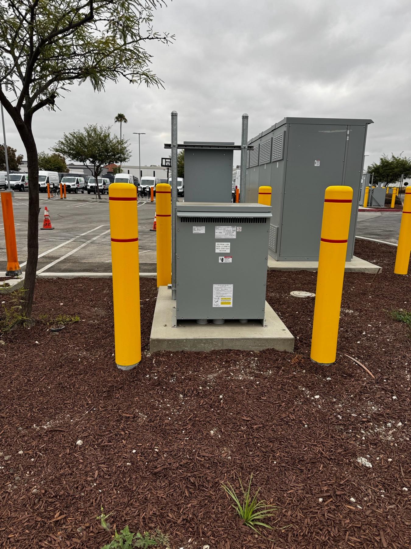 Pad-mounted electrical equipment protected by yellow bollards